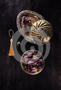 Dried Rose flowers in a vintage casket on an antique metal tray