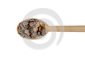 Dried rose hip fruit in wooden spoon isolated on white background. Herbs and food ingredients