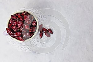 Dried rose hips in enameled mug top view on white background