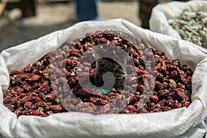 Dried rose hips in a sack at a market for sale. Dog roses Close up shot.
