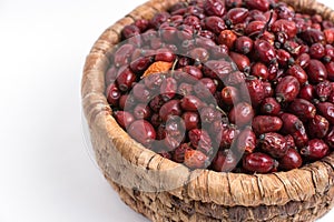 Dried rose hips in wicker basket isolated on white background