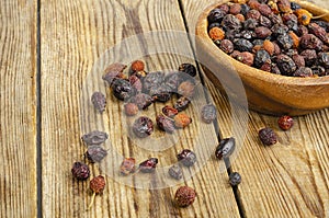 Dried rose hips in wooden bowl, natural vitamin C