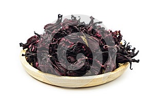 Dried Roselle flower buds in wooden bowl on white background