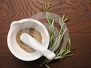 Dried rosemary in a mortar with a pestle