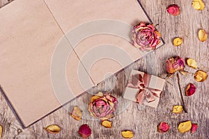 Dried roses and an open book. Paper background. Romantic background. Gift box