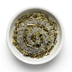 Dried rubbed sage in white ceramic bowl isolated on white from above photo
