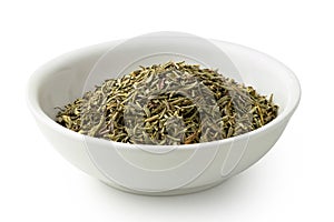 Dried rubbed thyme in a white ceramic bowl isolated on white