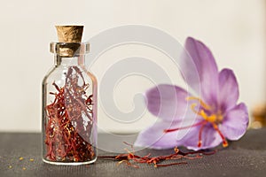 Dried saffron spice in a bottle and Saffron flower