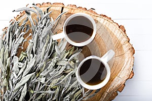 Dried sage branches, sage hot tea, on a piece of natural wood, natural remedies, natural medicine