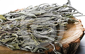 Dried sage branches, sage hot tea, on a piece of natural wood, natural remedies, natural medicine