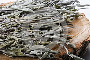 Dried sage branches, sage hot tea, on a piece of natural wood, natural remedies, natural medicine