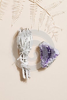 dried sage and druse amethyst on beige background, magic rock for ritual, witchcraft, spiritual practice, meditation.