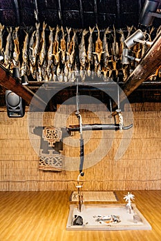 Dried salmons and fireplace inside house of Shiraoi Ainu Village Museum in Hokkaido, Japan