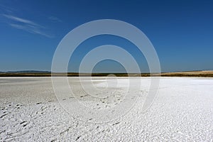 Dried salt lake under a bright blue sky. photo