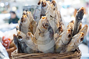Dried salted perch fish in basket close up, dry sea bass sale on seafood market, tasty stockfish, jerky grouper, salty sunfish