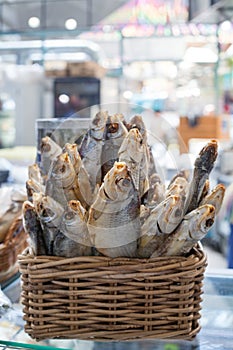 Dried salted perch fish in basket close up, dry sea bass sale on seafood market, tasty stockfish, jerky grouper, salty sunfish