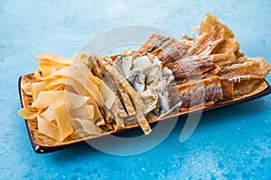 Dried Seafood Mix with Squid, Tuna, codfishon, yellow minke on Plate Top View. Cured Dehydrated Fish Fillet as Beer Snack