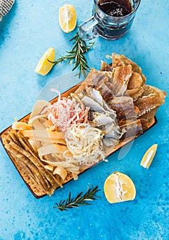 Dried Seafood Mix with Squid, Tuna, codfishon, yellow minke on Plate Top View. Cured Dehydrated Fish Fillet as Beer Snack