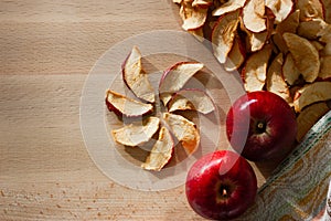 Dried slices of apple and red apples on the table. Top view.