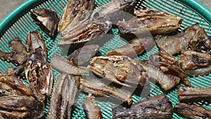 Dried slices of snake-head fish are laid out on plastic trays to dry in the sun.