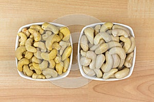 Dried and soaked Cashew nut seeds in white bowl on wooden background