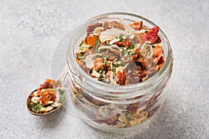 Dried spices, sun-dried tomatoes, dried carrots, Basil and herbes de Provence in a glass jar Copy space