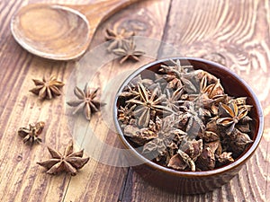 Dried star anise in small brown bowl