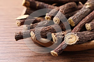 Dried sticks of liquorice root on wooden table, closeup