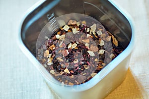 Dried tea leaves in metal bowl. Dried herbs tea leaves close up. Different dry herbs and flowers for making healthy tea background