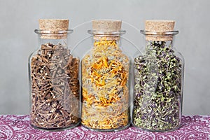 Dried teas herbs inside glass bottles.