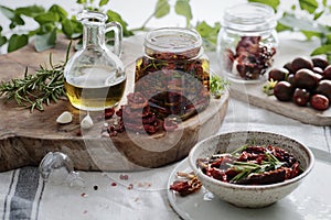 Dried tomatoes in a jar with fresh spices and olive oil