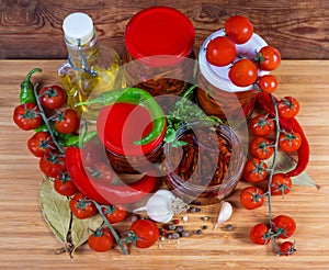 Dried tomatoes in oil, preserved chili in jars, top view