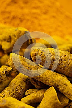 Dried turmeric root and turmeric powder close-up macro.