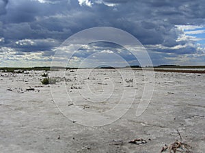 A dried-up riverbed of the salt lake desert the naked bottom of the reservoir in Kazakhstan with storm clouds nature landscape