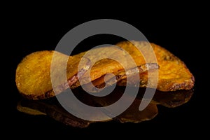 Dried vegetable chips isolated on black glass