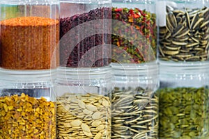 Dried vegetables in glass jars, onions, beets, carrots, pumpkin, bay leaf, banks on blurred background. Superfoods, herbs.