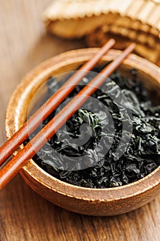 Dried wakame seaweed in bowl on wooden table