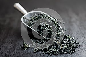 Dried wakame seaweed in scoop on black table