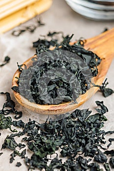 Dried wakame seaweed in spoon on kitchen table