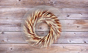 Dried wheat stalk wreath on rustic wooden boards