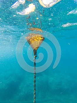 Drifter floating device, yellow buoy as seen from inside the water in the mediterranean sea, Catalonia, Spain