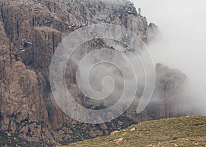 Drifting clouds partially conceal the mountain face.