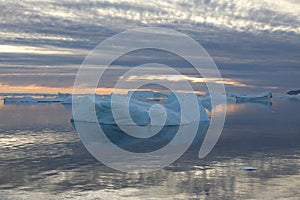 Drifting icebergs at sunset in a fjord in northwest Greenland