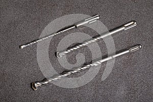 Drill bits for drilling concrete masonry or stone