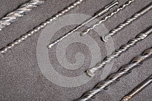 Drill bits for drilling concrete masonry or stone