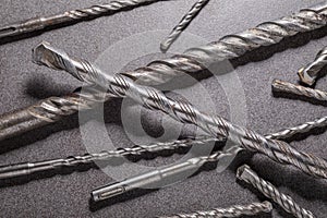 Drill bits for drilling concrete masonry or stone