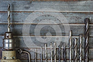 Drill and drill bits old metal background .