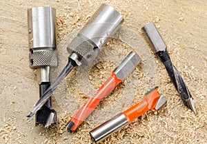 Drill bits and the scale on a wooden background