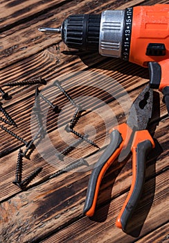 Drill, cutters and screws on a wooden old table