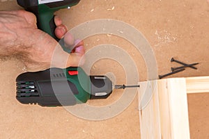 Drill driver whit screw on wooden background
